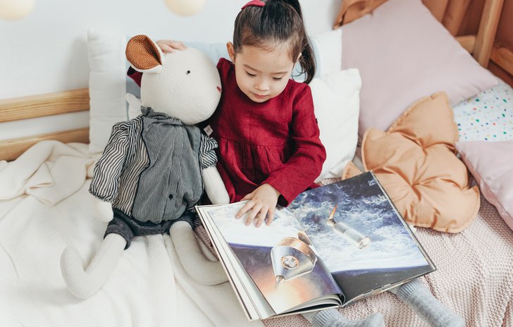 Girl reading to teddy