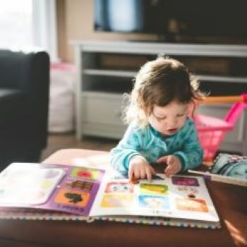 little girl reading a picture book